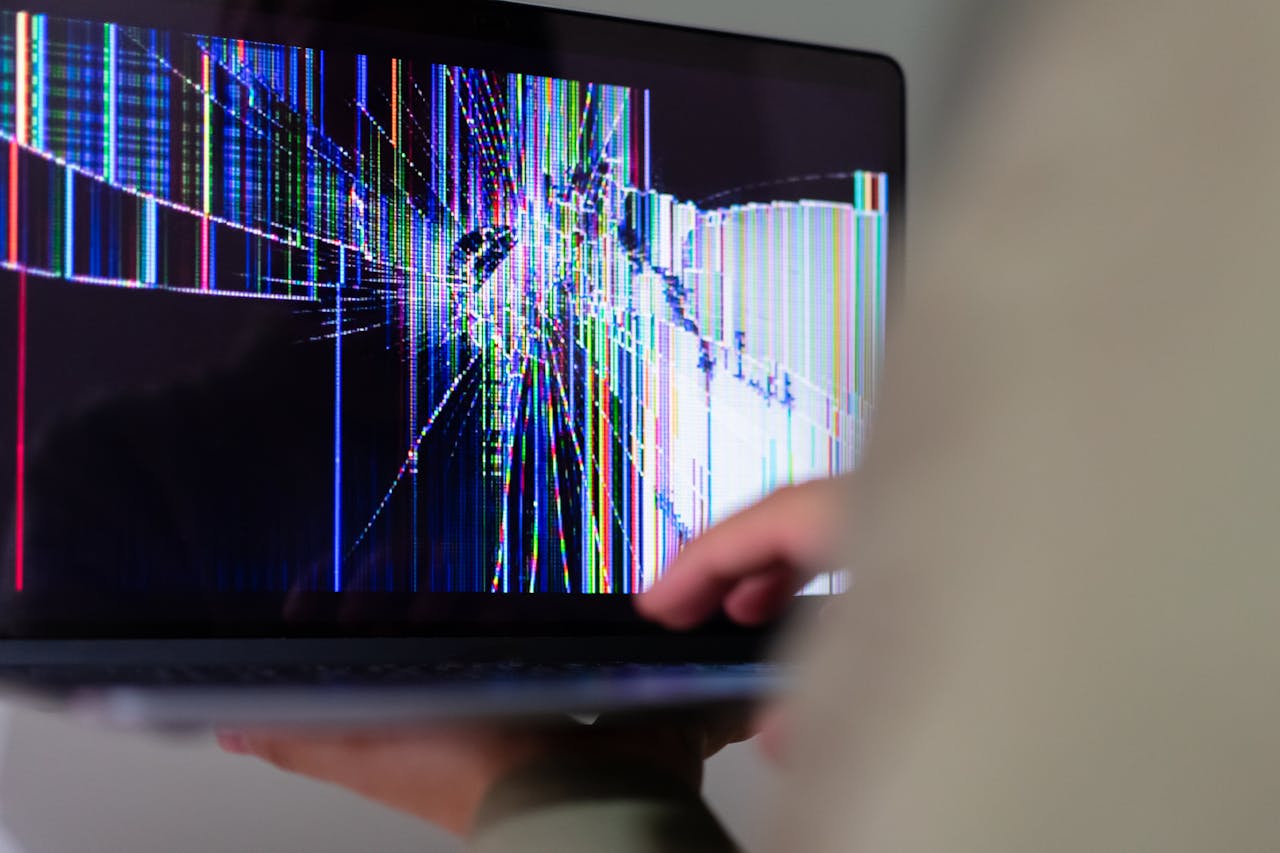 stats-img A close-up view of a cracked laptop screen displaying colorful digital distortion.